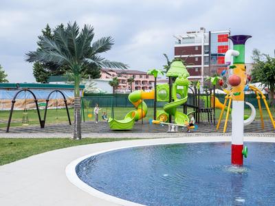 Kinderspeelplaats met glijbanen en watergebied in een vakantiepark.