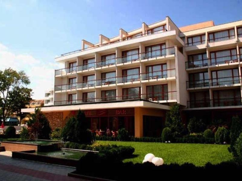 Modern hotelgebouw met meerdere balkons en groene tuin aan de voorkant.