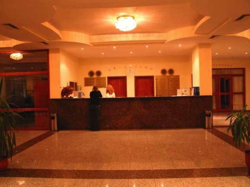 Gezellige hotellobby met receptiebalie en warme verlichting.