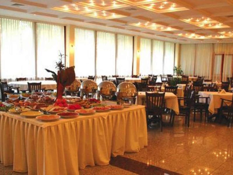 Grote eetzaal met buffettafel en veel gedekte tafels in een hotel.