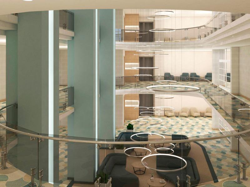 Moderne Hotellobby mit Sitzbereich, Glasgeländer und mehrstöckigem Innenhof.