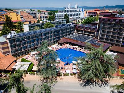Hotelanlage mit großem Außenpool, Liegestühlen und umliegenden mehrstöckigen Gebäuden.
