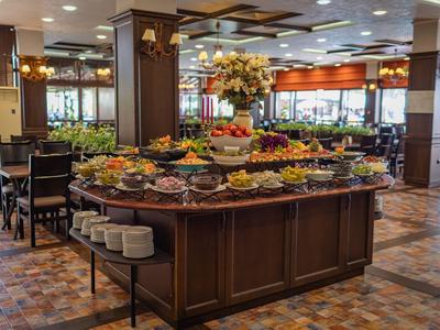 Buffetbereich mit vielfältigem Obst- und Gemüsetisch in einem hellen Restaurant.