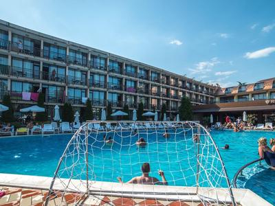 Großer Hotel-Swimmingpool mit Gästen und Sonnenschirmen an klaren, sonnigen Tag.