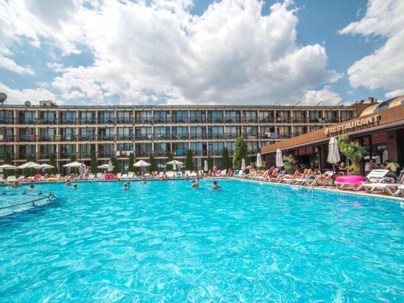 Groot buitenzwembad voor een modern hotel met veel gasten en parasols.