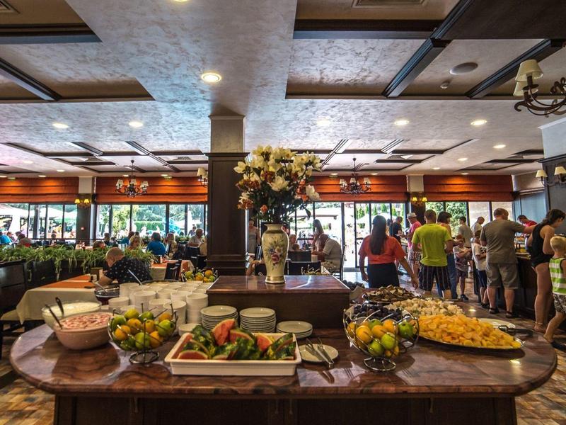 Hotelrestaurant met buffet en gasten in een elegante, rustieke omgeving.