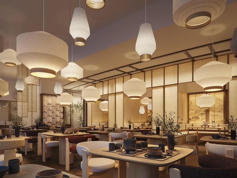 Restaurante moderno de hotel con iluminación elegante y zonas de asientos cómodas en tonos cálidos.