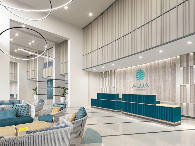 Moderna recepción de hotel con techos altos, bancos azules y iluminación elegante.