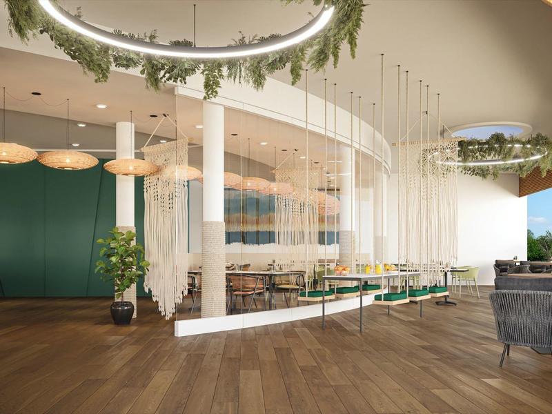 Área de lounge moderna en hotel con muebles elegantes y grandes ventanales.