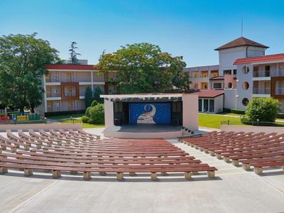 Openluchtpodium met zitplaatsen in een hotelcomplex bij heldere lucht