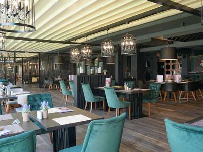 Moderne eetzaal met groene stoelen en hangende kroonluchters