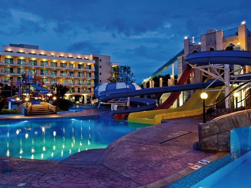 Hotel met verlicht zwembad en glijbaan 's nachts