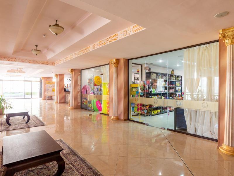 Spacious, elegant hotel hallway with marble floor and ornate columns.