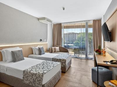 Modernes Hotelzimmer mit zwei Einzelbetten, Balkon und Stadtblick.