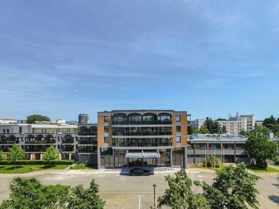 Modernes Hotelgebäude mit Glasfront und angrenzenden Balkonen unter blauem Himmel.