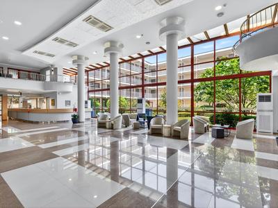 Großzügige Hotellobby mit moderner Möblierung und großen Fenstern zum Garten.