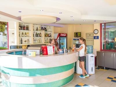 Hotel reception with a guest and a receptionist behind the counter.