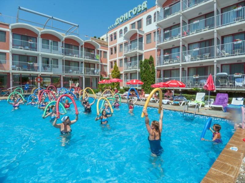 Hotel pool with guests lifting colorful swim rings and enjoying the water fun.