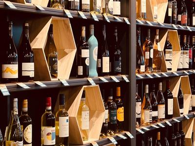 Weinregal mit vielen Flaschen und sechseckigen Holzboxen, angeordnet in mehreren Reihen.