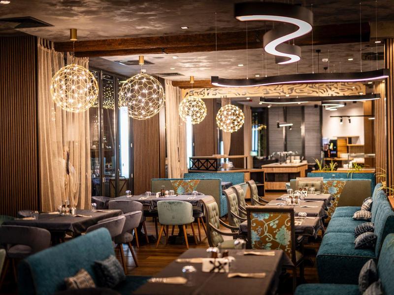 Modern eingerichteter Hotelrestaurantbereich mit stilvollen Lampen und gemütlichen Sitzgelegenheiten.