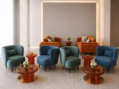 Ein moderner Lounge-Bereich mit blauen und grünen Sesseln und kleinen Holztischen mit Dekoration.