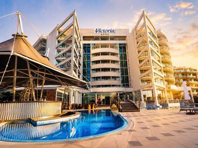 Nowoczesny hotel z basenem i otwartym barem o zachodzie słońca.