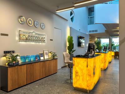 Nowoczesna recepcja hotelowa z oświetlonym ladą i przytulną atmosferą.