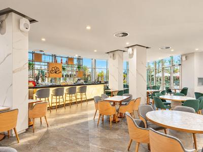 Jasna, nowoczesna strefa lounge hotelu z miejscami do siedzenia i barem.
