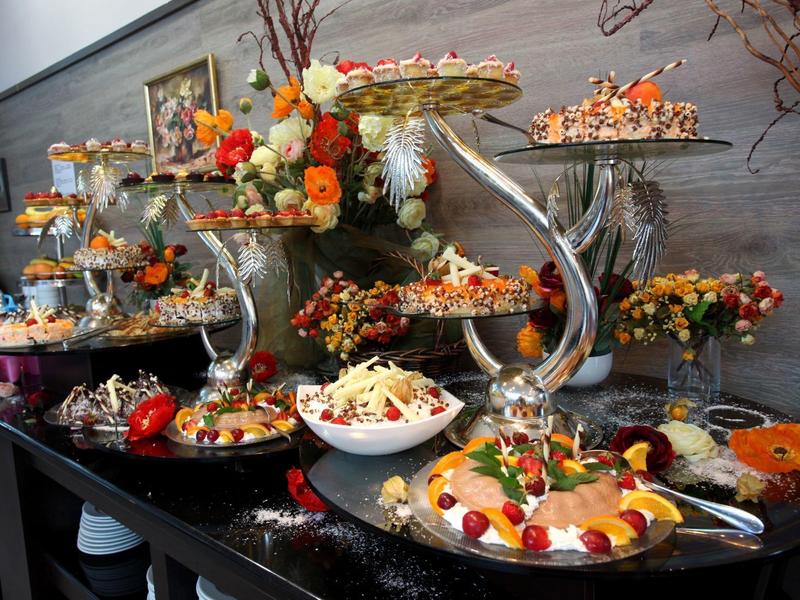 Elegante buffettafel met mooi gerangschikte fruit, desserts en bloemstukken.