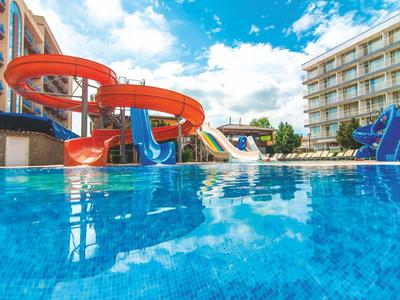 Wasserpark mit verschiedenen Rutschen neben einem Hotel unter blauem Himmel