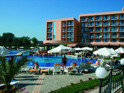 Hotel mit einem Pool, Sonnenschirmen und Liegestühlen im Freien bei klarem Himmel