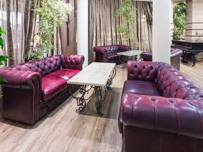 Living room with two purple leather sofas and a marble table in a modern setting.