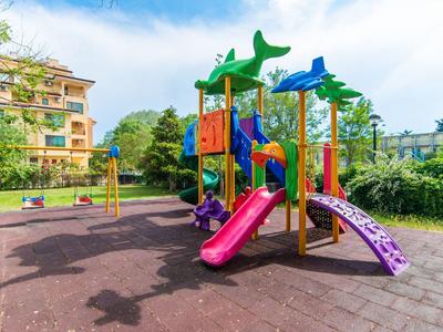 Colorful children's playground with slides and climbing structures outdoors under a blue sky.