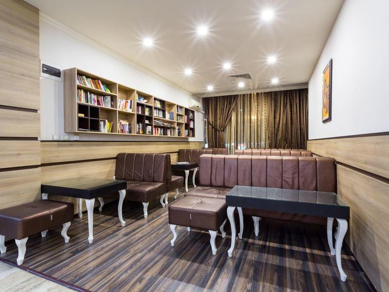 Modern waiting area with brown seating, bookshelves, and warm lighting.