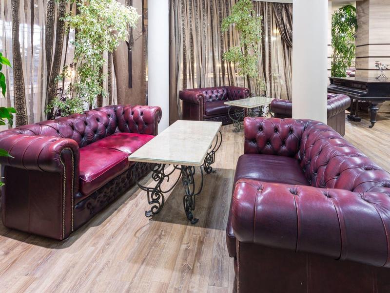 Living room with two purple leather sofas and a marble table in a modern setting.