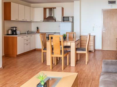 Moderner, heller Küchen- und Essbereich mit Holzmöbeln und hellen Wänden in einer Ferienwohnung.