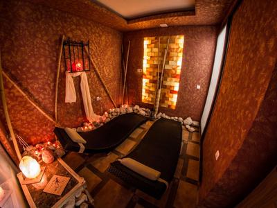 Cozy wellness room with two black lounge chairs and relaxing lighting.