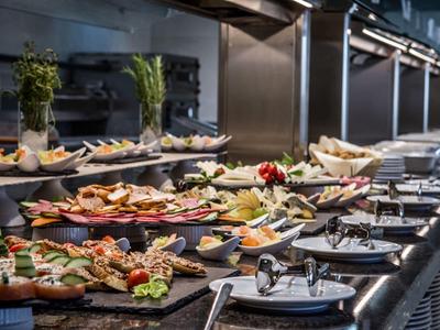 Buffet with diverse cold appetizers and platters in a dining area.