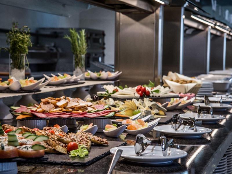 Buffet with diverse cold appetizers and platters in a dining area.