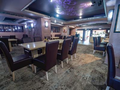 Moderner Hotel-Loungebereich mit Tischen, Stühlen und gedämpfter Beleuchtung.