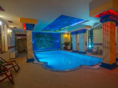 Indoor pool with blue lit ceiling and color-accented pillars in a hotel