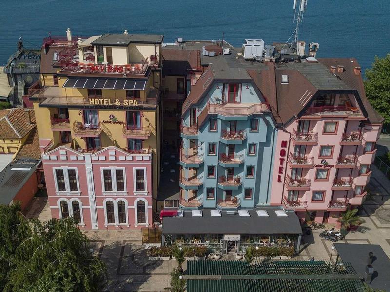 View of colorful historic hotel buildings with balconies near a body of water.