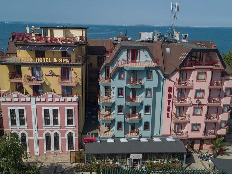 Several colorful hotels with sea view under clear sky.