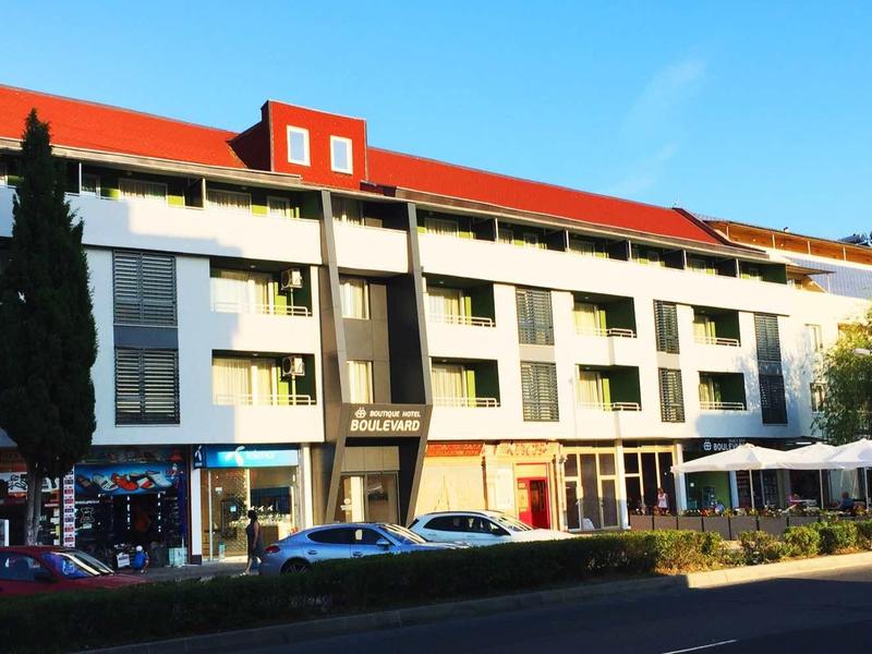 Modern hotel met witte muren, rode daken en zitgedeeltes buiten.