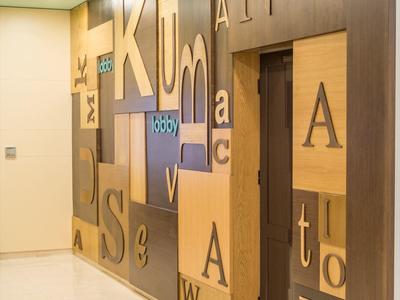 Hallway with wooden panel wall featuring large letters in various sizes.