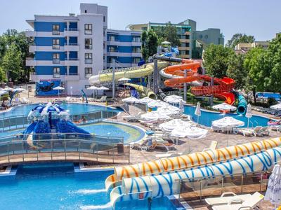 Colorful water slides and pools in a lively water park with sun umbrellas and lounge chairs.
