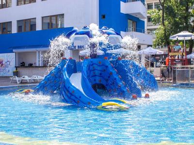 Colorful water playground with slides and sprays in a hotel swimming pool.