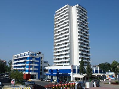 Modern tall hotel building with white and blue design under clear sky
