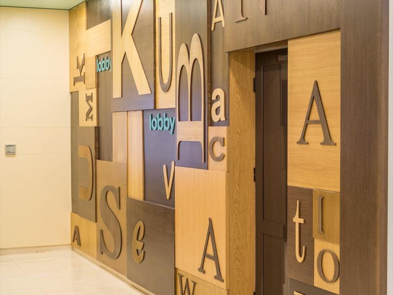 Hallway with wooden panel wall featuring large letters in various sizes.