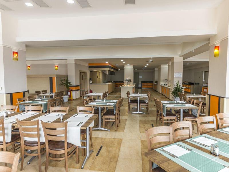 Bright and modern restaurant with wooden tables and chairs set for guests.